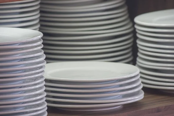 把一堆白色干净的盘子放在木架子上 准备早晨的自助餐 软焦点 — 图库照片