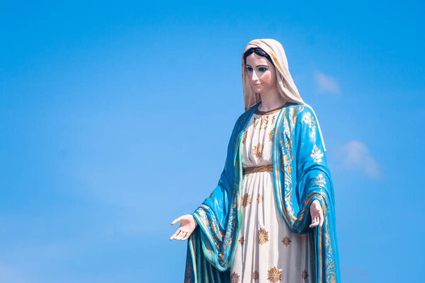 The Blessed Virgin Mary statue standing in front of the Roman Catholic Diocese with blue sky background at Chanthaburi Province, Thailand.