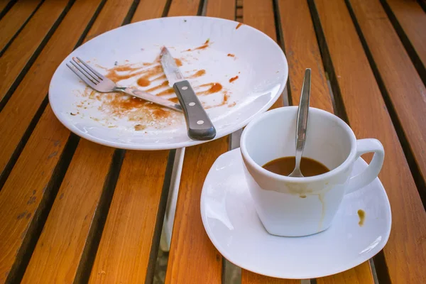 白い皿 ナイフとフォークを白の汚れた皿の上に汚いコーヒー カップとスプーンを閉じます 木製のテーブル上にあるビンテージ スタイルの朝は朝食を食べたら — ストック写真