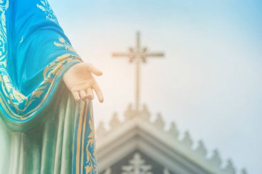 Kutsal bakire Meryem heykeli duran haç veya çapraz ve Chanthaburi Eyaleti, Tayland at arka planda mavi gökyüzü ile Roma Katolik piskoposluk önünde el.