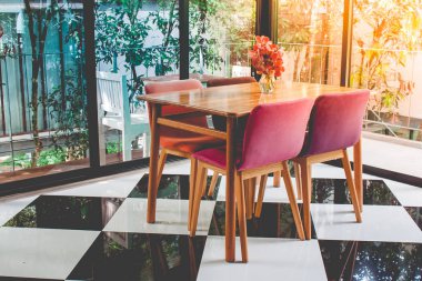 Vintage renkli ahşap masa ve sandalye güneş ışığı ile restoranda damalı deseni katta üst sol köşeden yaymak.