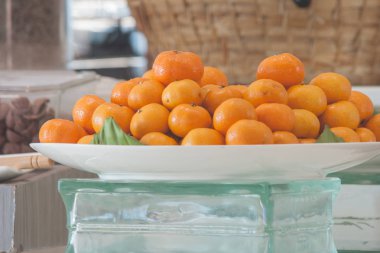 Küçük portakal meyve sabahları kahvaltı için beyaz tabakta yığını. (Yumuşak odak)