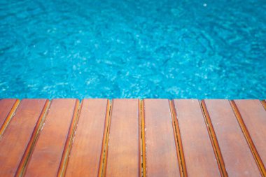 Uzun sandalyeyle yüzme havuzunun içinde belgili tanımlık geçmiş mavi su ile. (Seçici odak)