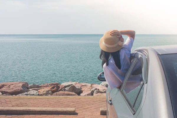 Vacation and Holiday Concept : Happy family car trip at the sea, Portrait woman wearing weave hat and feeling happiness in silver car.