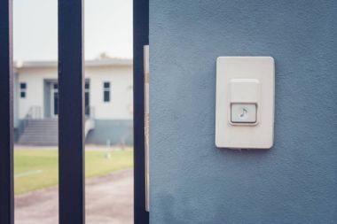 Beyaz kapı zili veya beton duvar kapı ev içinde belgili tanımlık geçmiş yanında buzzer düğmesini kapatın.