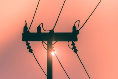 Silhouette elektrik direği ve yüksek gerilim enerji hattı içinde belgili tanımlık geçmiş gün batımı ile. (Seçici odak)