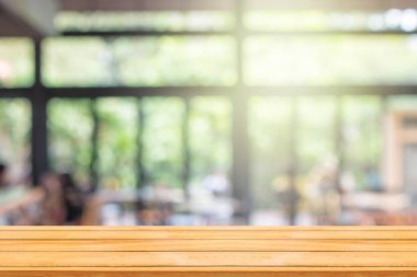 Ürün gösterimi ve reklamcılığı için arka planda kahve dükkanı ya da kafe restoranının soyut bulanık görüntüsü olan boş tahta masa.