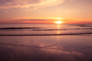 Alacakaranlık vakti, Chaolao Sahili, Chanthaburi, Tayland 'da deniz dalgası ve turuncu günbatımı ile tropik güzel deniz manzarası