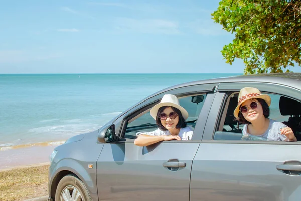 Summer Vacation and Car Trip Concept : Family car trip at the sea, Woman and child cheerful in car with seascape in the background, They feeling happiness.