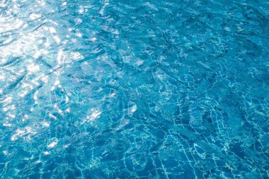 Soyut görüntü güneş ışığı yüzme havuzundaki mavi suyun yüzeyine yansıyor. (Seçici odaklanma)