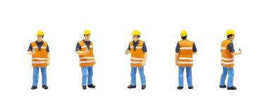 Minyatür figür karakteri, güvenlik yeleği giyen ve beyaz arka planda izole bir şekilde poz veren işçi..