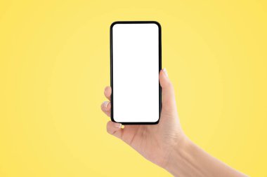 İş İletişim Konsepti: Sarı arka planlı eski siyah akıllı telefon.