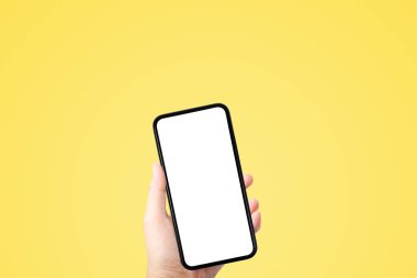 İş İletişim Konsepti: Sarı arka planlı eski siyah akıllı telefon.