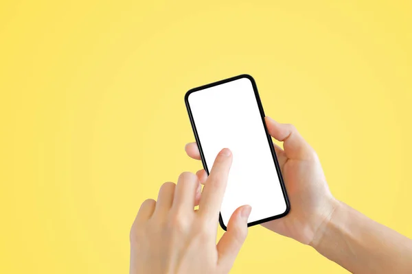 ビジネスコミュニケーションコンセプト 黄色い背景の古い黒いスマートフォンを手で握る — ストック写真
