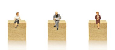 CORONA Virüsü ve Sosyal Mesafe Kavramı: Tahta blokta oturan ve büküm riskini azaltmak ve Corona virüsünü korumak için mesafeyi koruyan insanlar.