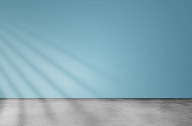 Mavi duvarlı boş uzay odası ve parlak gölgeli beton zemin.