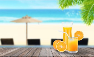 Hoş geldin. Portakal suyu kokteyli, ahşap masaya konur. Arka planda bulanık mavi su ve deniz manzarası vardır..