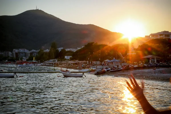 Elveda, yaz. Sahilde güneşin dağın üstünden, gün batımı (Budva, Karadağ gittiği yere kapalı el sallayarak)