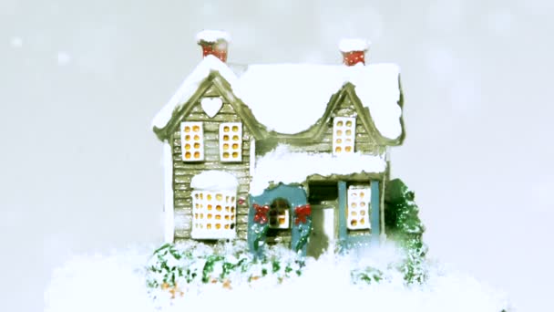 Nieve cayendo alrededor de casa pequeña — Vídeos de Stock