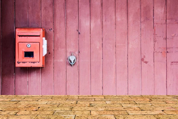 Kotak surat merah di pintu kayu merah Stok Foto
