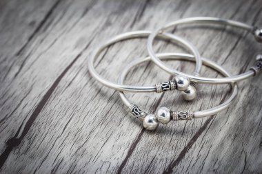 Ahşap arka plan üzerinde gümüş bilezik