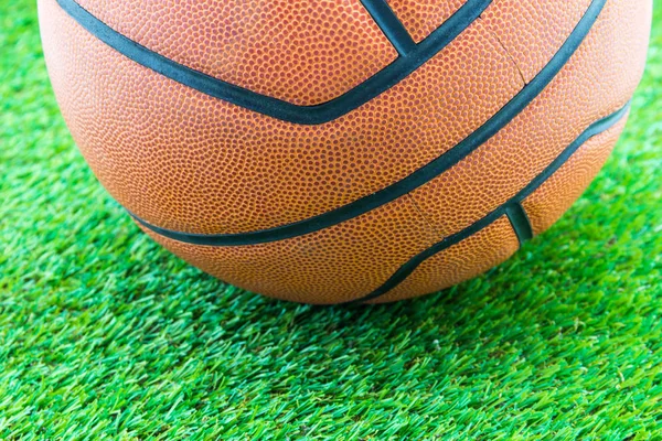 Basketbal op groen gras achtergrond — Stockfoto