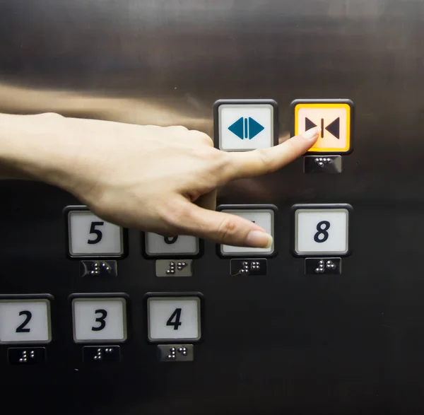 Elevator button is pushed by a female finger