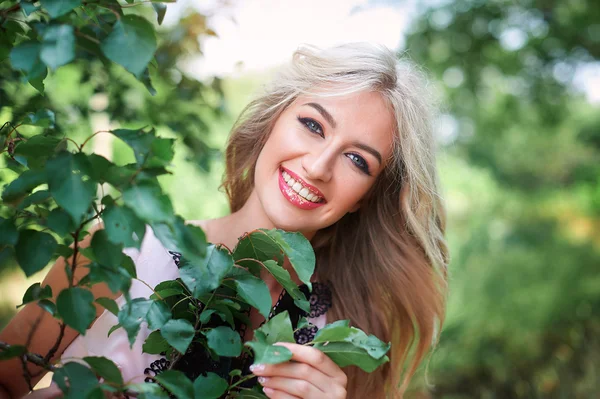Krásná mladá blondýnka dívka v parku — Stock fotografie