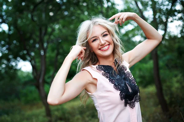 Frau mit langen blonden Haaren posiert im Sommerpark — Stockfoto