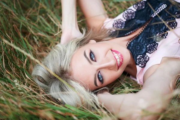 Giovane donna felice sdraiata sull'erba all'aperto — Foto Stock