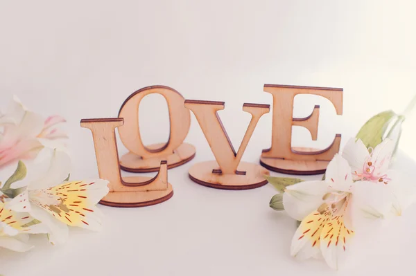 Decoratieve brieven vormen woord liefde met wilde bloemen op houten achtergrond — Stockfoto