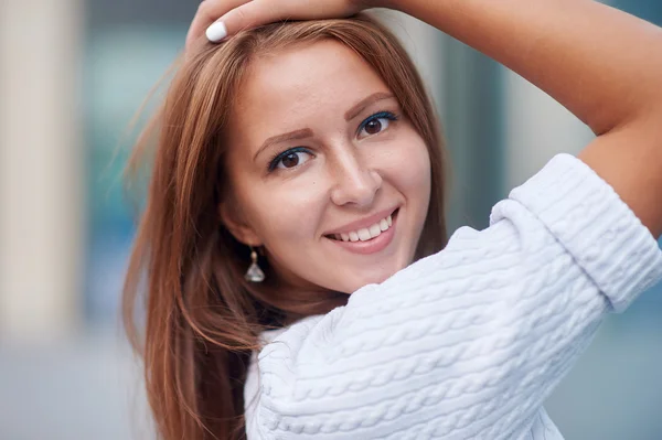 Hermosa mujer sonriente cerca de la ventana en la calle —  Fotos de Stock