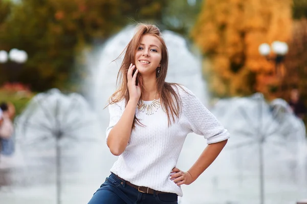 Junge schöne Frau geht und posiert in der Stadt in der Nähe von Brunnen — Stockfoto