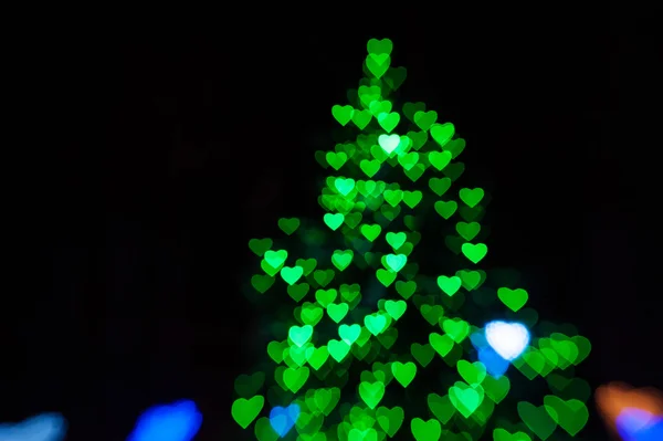 Schöne grüne Bokeh in Form von Weihnachtsbaum auf schwarzem Hintergrund — Stockfoto