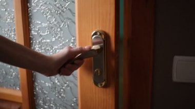 Kadın el açılış ahşap kapı. Altın kapı kolundan tutarak