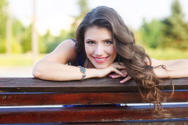 Młoda piękna kobieta spoczywa na ławce w parku lato — Zdjęcie stockowe
