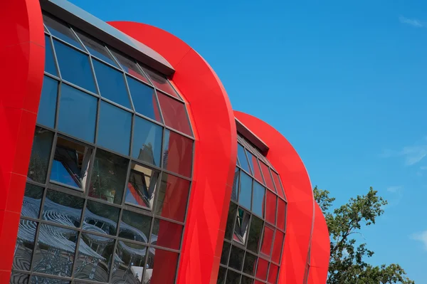 Facciata rossa blu edificio moderno di una luminosa giornata di sole con cielo limpido. Spazio per testo — Foto Stock