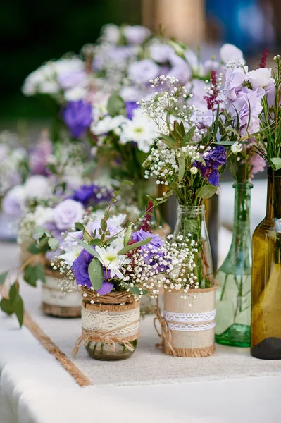 Decoración de boda rústica, estilo provence. Ramo de flores de lavanda y frascos de especias de vidrio en la mesa de madera —  Fotos de Stock