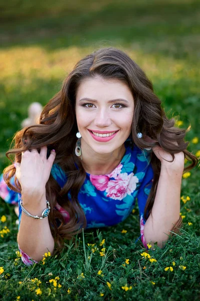 Parktaki çimlerin üzerinde uzanan güzel genç bir kadın.