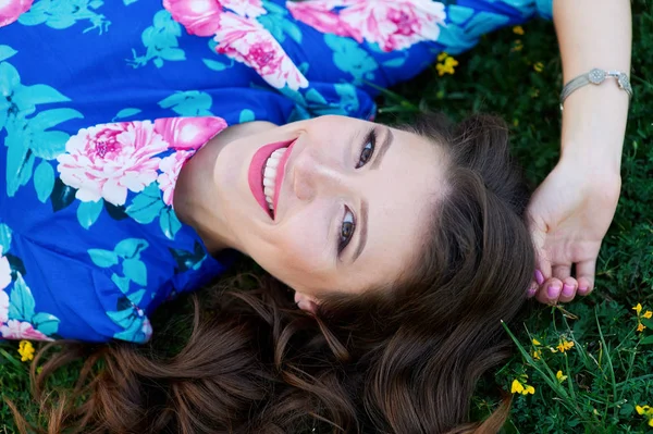 Schöne junge Frau liegt auf dem Gras im Park — Stockfoto
