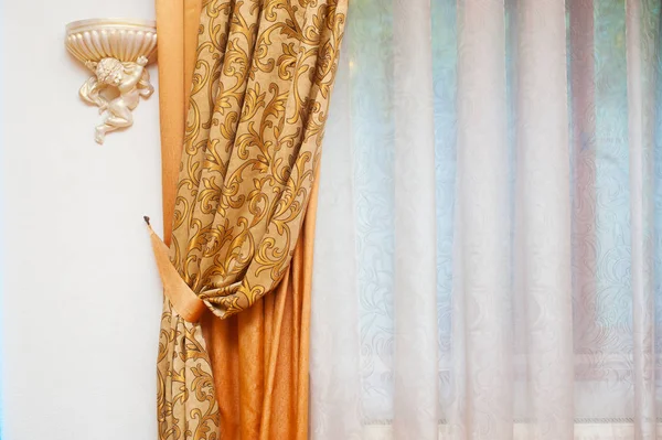 Teil des schön drapierten Vorhangs und der Wand mit Mustern — Stockfoto