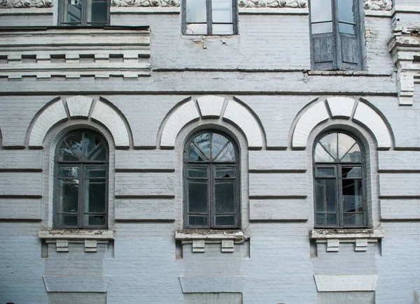 Fachada de antiguo edificio abandonado con tres grandes ventanas arqueadas — Foto de Stock