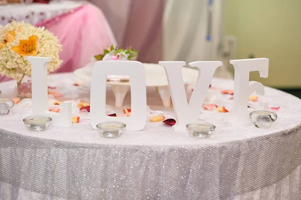 Letras brancas de madeira AMOR sobre a mesa. Decoração de casamento — Fotografia de Stock