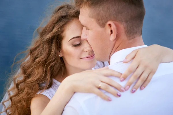 Bride and groom hugging at the background of water — Stock Photo, Image