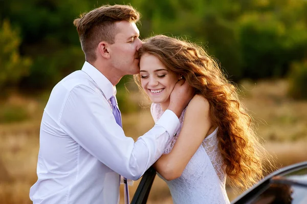 Noivo beijando noiva na cabeça na caminhada do casamento — Fotografia de Stock