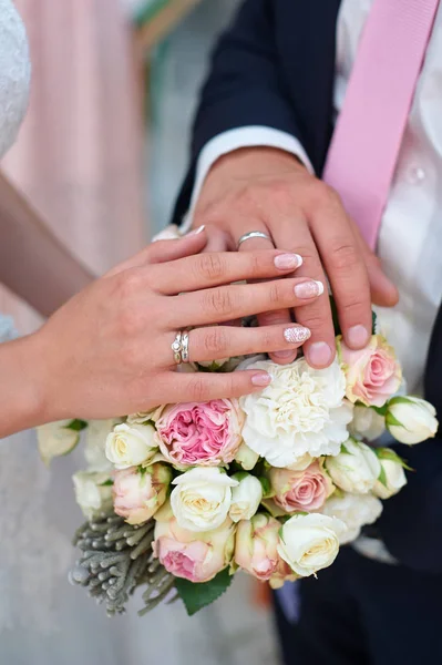 Το χέρι της νύφης και του γαμπρού με δαχτυλίδια για γαμήλια ανθοδέσμη — Φωτογραφία Αρχείου