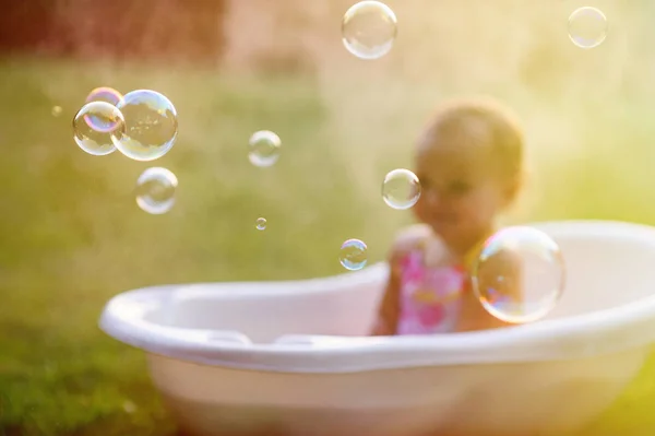 Niña se lava en el baño en la hierba verde —  Fotos de Stock