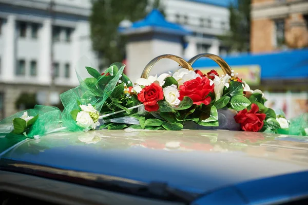 Bröllop bil dekorerad med röda blommor — Stockfoto