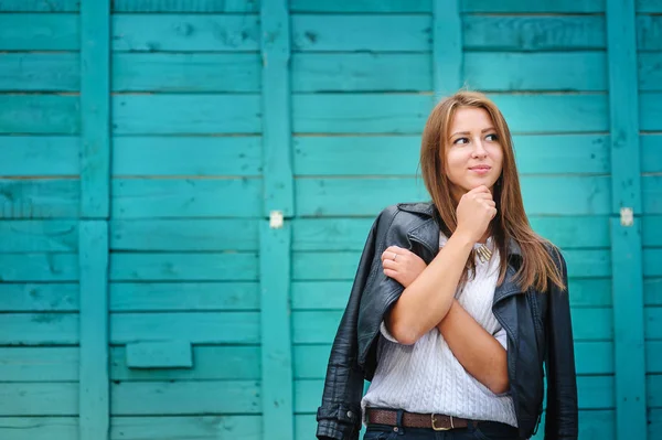 Lächelnde junge Frau posiert gegen Holzzaun — Stockfoto