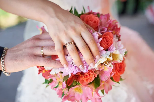 Main de la mariée et le marié à un bouquet de mariage — Photo